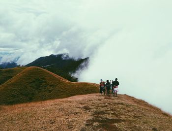 Rear view of people walking on mountain