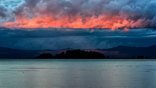 Scenic view of sea and mountains against sky