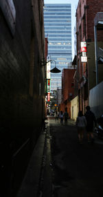 People walking on street amidst buildings in city