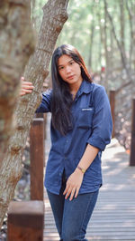 Portrait of young woman standing in forest