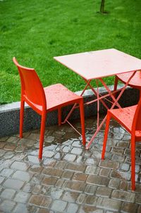 High angle view of empty chairs and table at sidewalk cafe