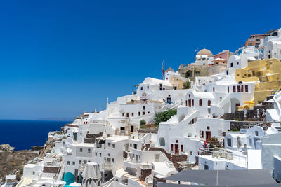 Panoramic view of oia town in santorini island with old whitewashed houses and traditional windmill