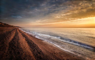 Scenic view of beach against sky during sunset