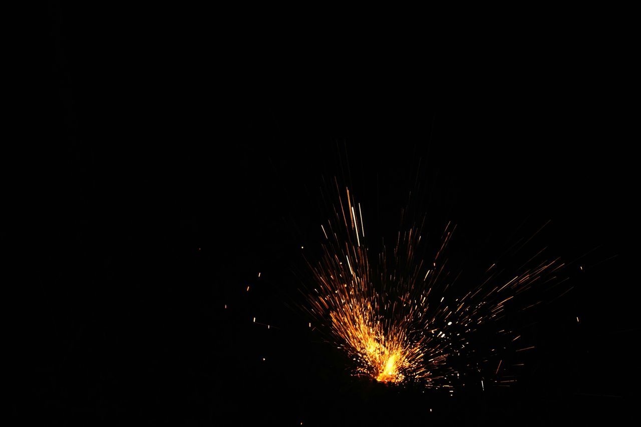 night, long exposure, illuminated, firework display, glowing, motion, exploding, firework - man made object, low angle view, sparks, celebration, fire - natural phenomenon, copy space, blurred motion, sky, arts culture and entertainment, dark, outdoors, no people, firework