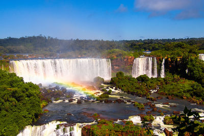 View of rainbow over waterfall
