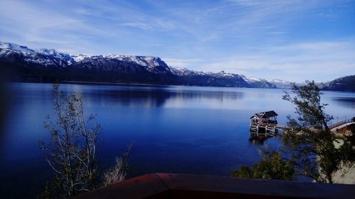 Scenic view of lake by mountains against sky