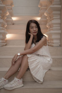 Portrait of young woman sitting at home