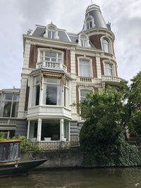 Low angle view of building by lake against sky