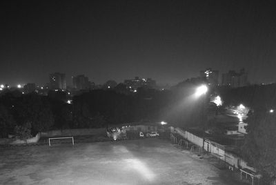 Illuminated street amidst buildings in city at night