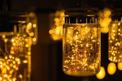 Close-up of illuminated light bulb in jars