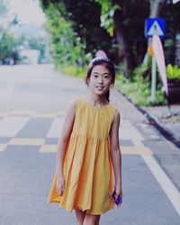 Portrait of smiling girl walking on road