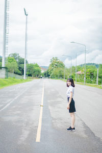 Full length of girl on road against sky