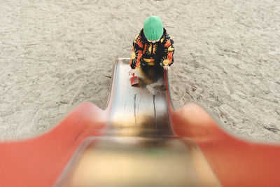 Girl standing on bottom of metal slide