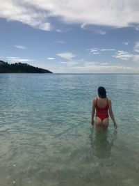 Rear view of woman in sea against sky