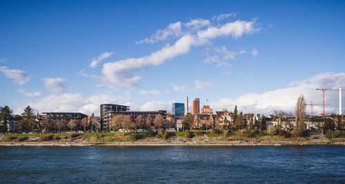 River amidst buildings in city against sky