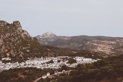 Town by mountain against clear sky