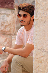 Man wearing sunglasses while sitting outdoors