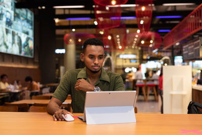Man using laptop at cafe