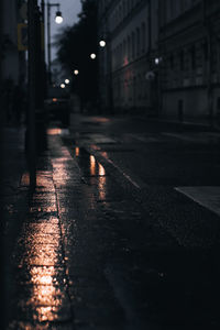 Dark evening street after rain with reflection in puddles