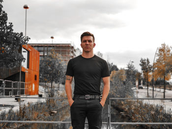 Young man standing against sky