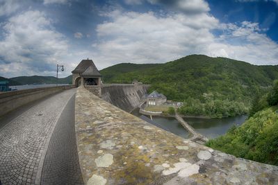 Scenic view of river by mountains against sky