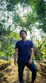 Portrait of young man standing in forest