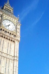 Low angle view of clock tower against blue sky