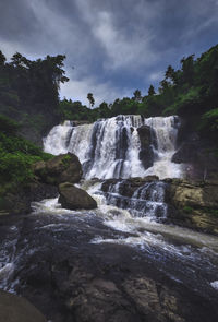 Scenic view of waterfall against sky
