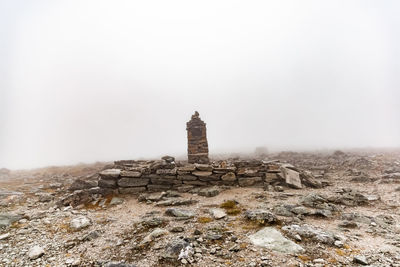 Historic building on rock against sky