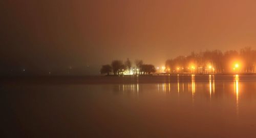Scenic view of lake against sky at night