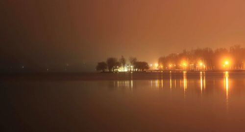 Scenic view of lake against sky at night