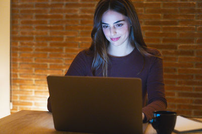 Young woman using laptop at table