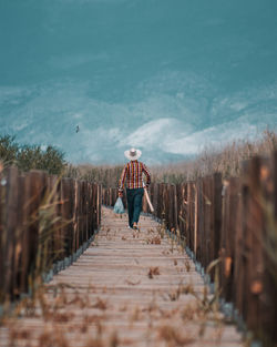 Rear view of man standing on footpath