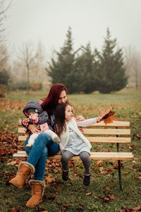 Woman sitting on bench in field