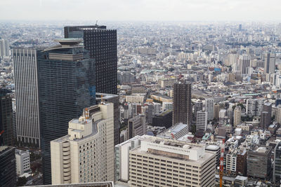 Aerial view of buildings in city against sky