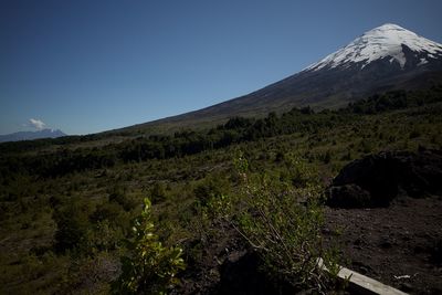 Scenic view of mountains against clear blue sky