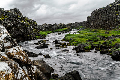 Rock formations by sea against sky