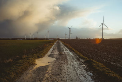 Road amidst field against sky