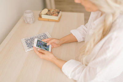Midsection of woman holding umbrella on table