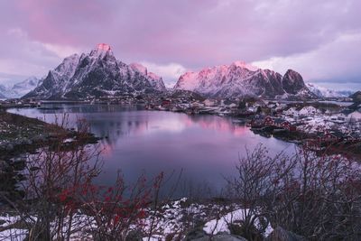 Scenic view of lake and snowcapped mountains against cloudy sky