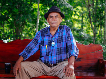 Portrait of young man sitting on bench