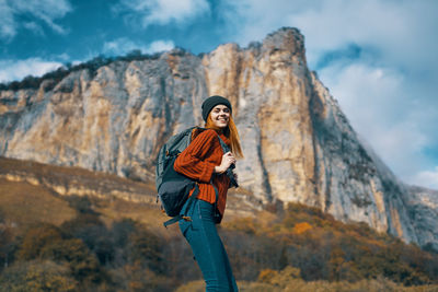 Woman standing on rock against mountain