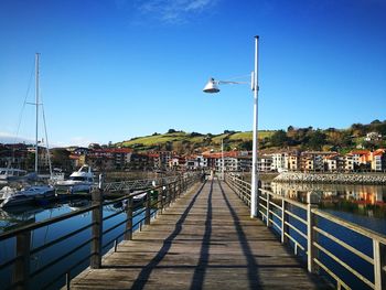 View of marina on pier against blue sky