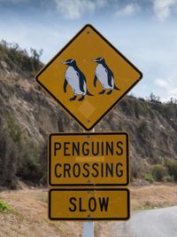 Close-up of road sign against sky