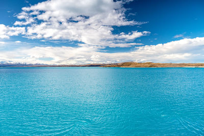 A scenic landscape of new zealand southern alps and lake pukaki with blue sky and clouds.