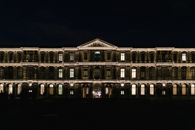 Reflection of illuminated building in water at night