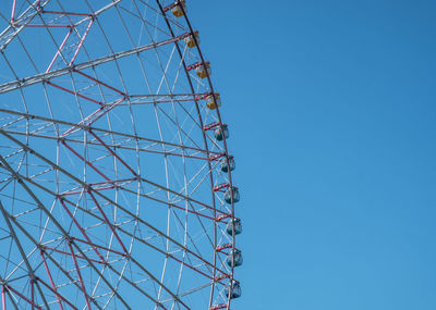 Low angle view of ferris wheel against blue sky