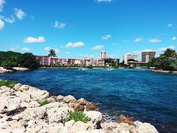 Scenic view of sea by city against sky