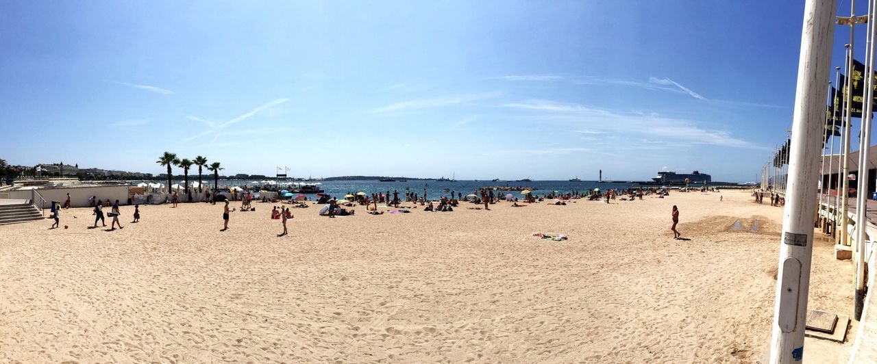 beach, sand, sky, sea, blue, water, shore, sunlight, built structure, horizon over water, day, sunny, incidental people, architecture, panoramic, nature, vacations, outdoors, tranquil scene, beach umbrella