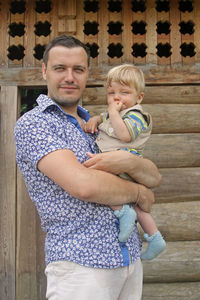 Portrait of father and son standing outdoors